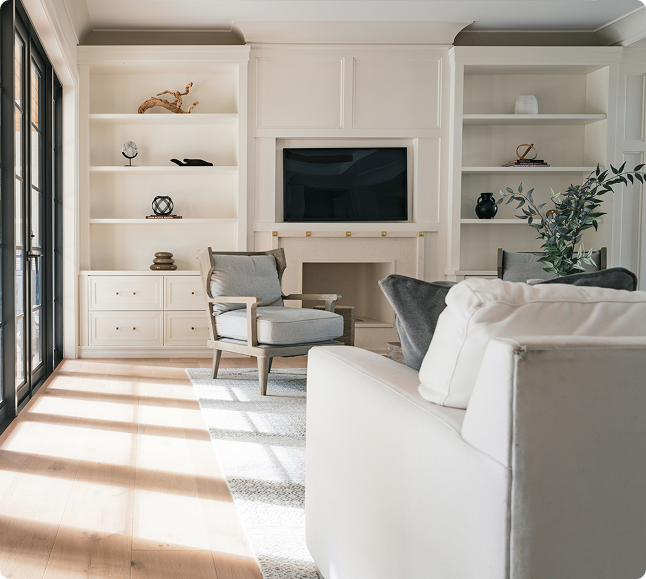 Interior living space with light-colored walls, modern furnishings, a cozy armchair, and decorative shelves, showcasing a blend of comfort and style ideal for coastal homes in Madeira Beach.