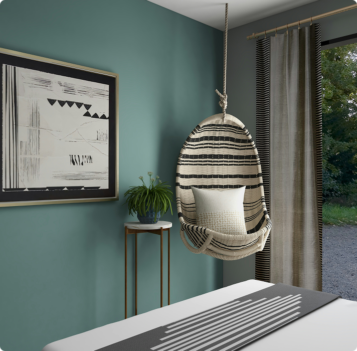 Interior room featuring a hanging chair with a striped design, teal walls, framed abstract artwork, a small plant on a gold side table, and a window with sheer curtains, reflecting a modern and inviting atmosphere suitable for interior painting inspiration.