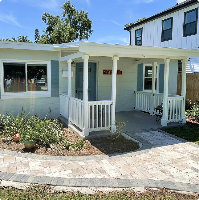 Home exterior featuring a freshly painted porch with white railings, blue shutters, and a welcoming entryway, showcasing quality craftsmanship by Attention to Detail Painting in Pinellas County.