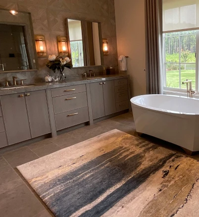 Gray bathroom vanity cabinets beside a freestanding tub