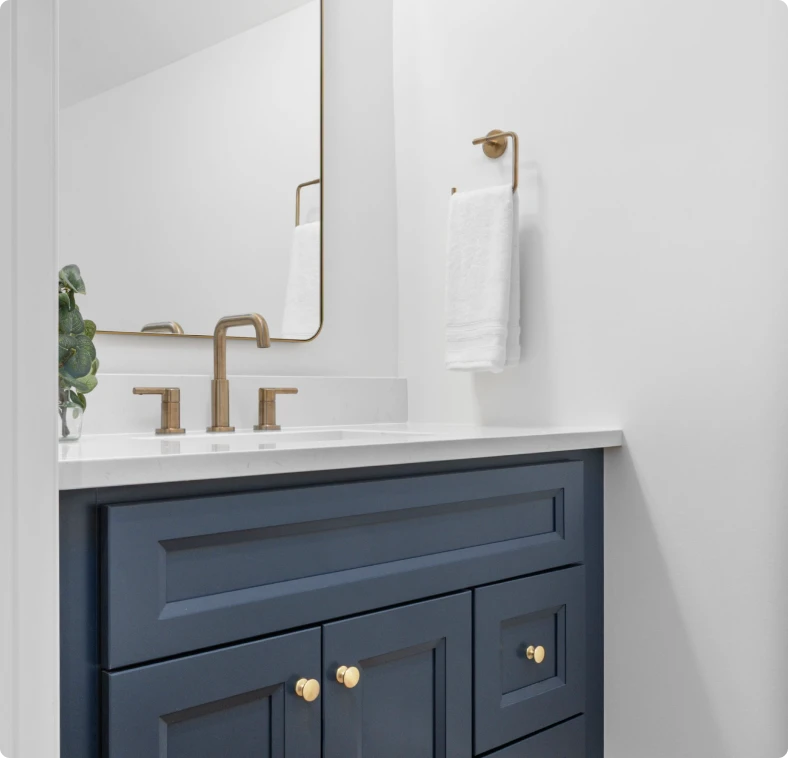 Navy blue bathroom vanity with brass faucet and hardware