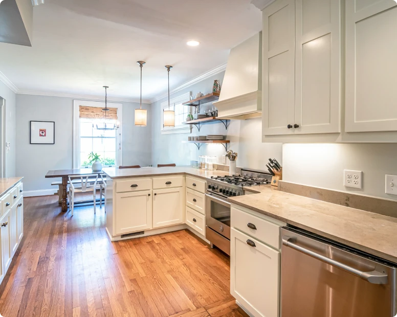 Cream kitchen cabinets with wood countertops and pendant lights