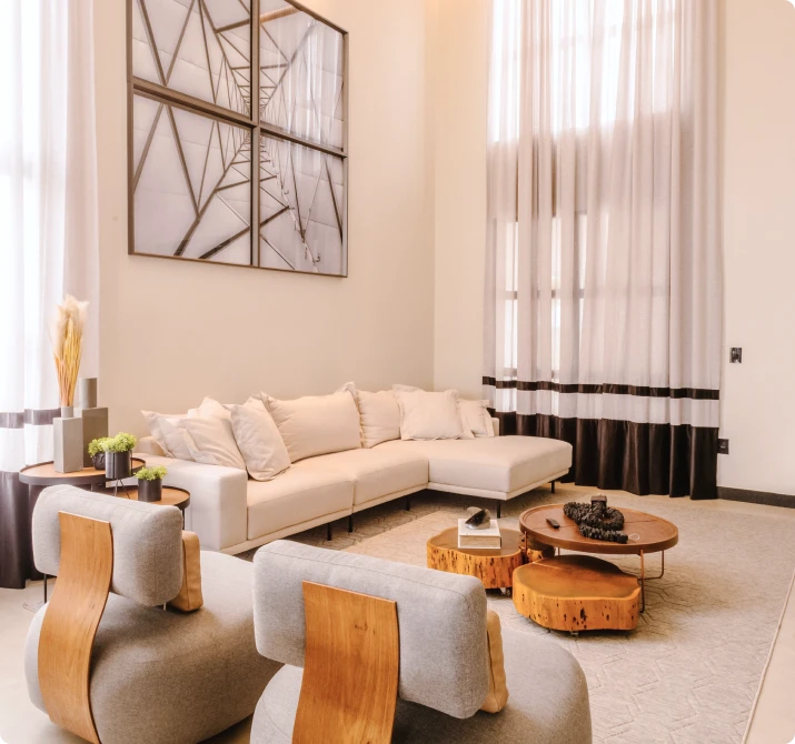 Living room with tall ceilings, a cream sectional and wood coffee tables